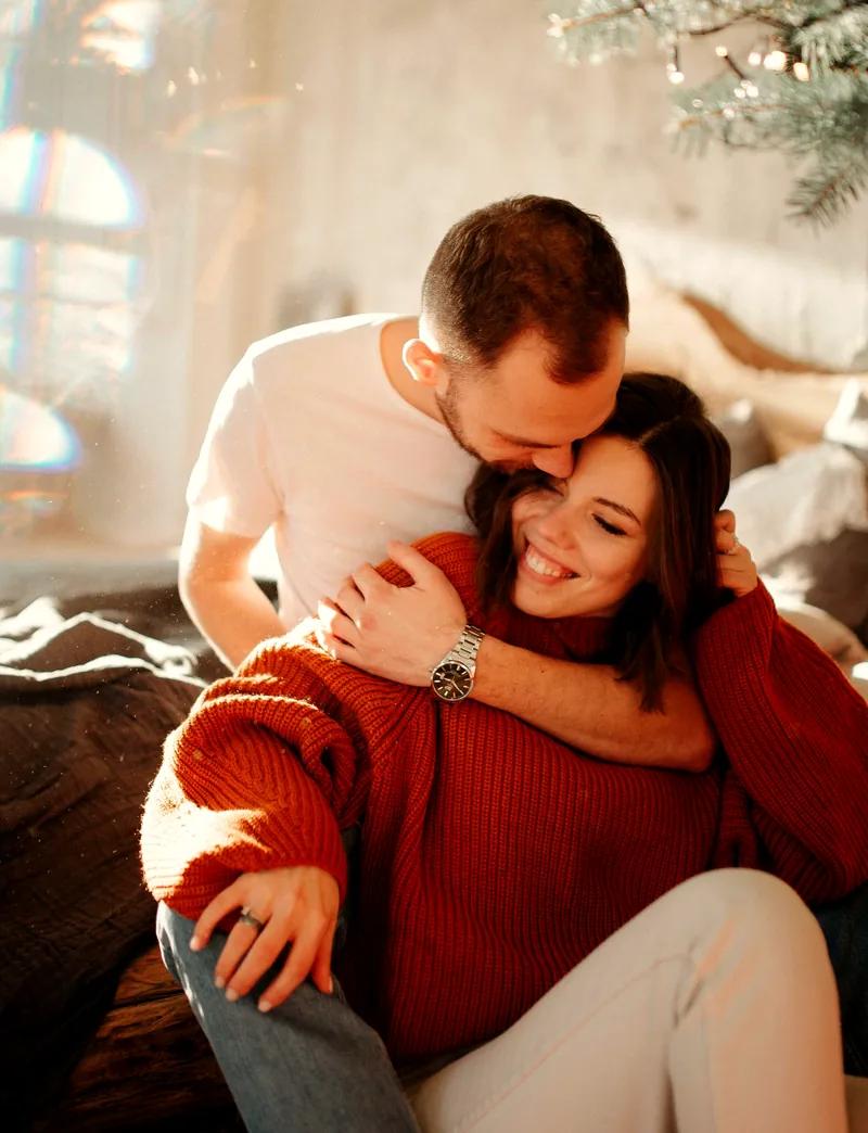 Casal abraçado e sorrindo, próximo, demonstrando cumplicidade